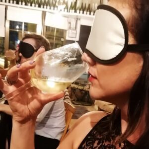 woman smelling glass of wine with blindfold