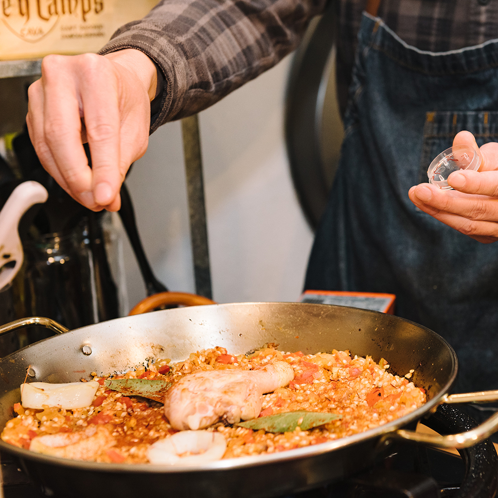 Attendee adding saffron to paella during cooking class